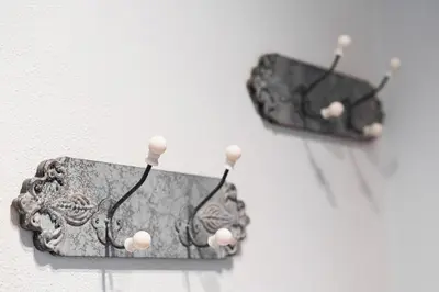 two earrings are hanging on a wall at GuestReady - Final Step in Porto