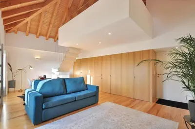 a blue couch in a living room with wooden walls at Sé do Porto - Loft with City View in Porto