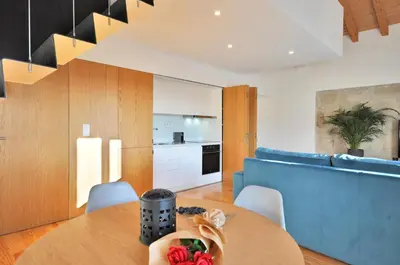 a kitchen and dining room with a table and a blue couch at Sé do Porto - Loft with City View in Porto