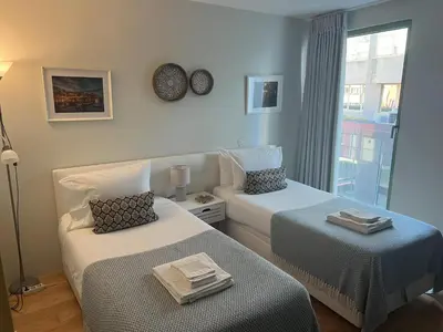 two beds in a room with a window at Duplex Apt - Sleeps 4 - Roof Terrace - Balcony in Porto