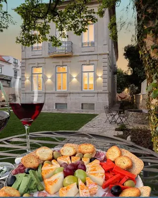 a plate of food on a table with a glass of wine at Casa Kala in Porto