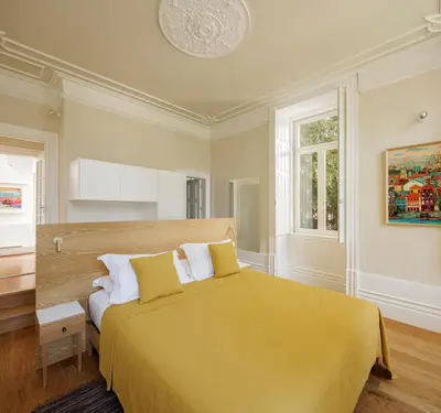 a bedroom with a yellow bed and a window at Casa Kala in Porto