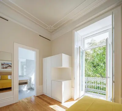 a white room with a large window and a bed at Casa Kala in Porto