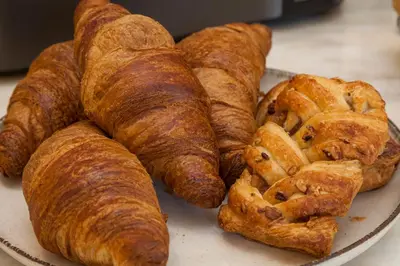 a plate of pastries and croissants on a table at Casa Kala in Porto