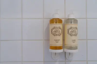 two bottles of liquid on a white tiled wall at Belleville in Porto