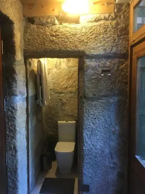 a bathroom with a toilet in a stone wall at Vérités Dame in Porto