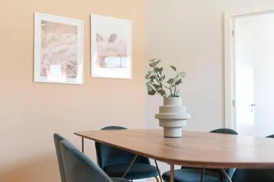 a dining room table with chairs and a vase with a plant at Central Superb Flat w/ AC & Balcony by LovelyStay in Porto