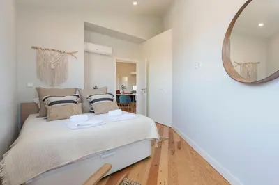a bedroom with a bed with a mirror on the wall at Central Superb Flat w/ AC & Balcony by LovelyStay in Porto