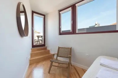 a room with a chair and a mirror and windows at Central Superb Flat w/ AC & Balcony by LovelyStay in Porto