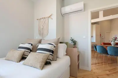 a living room with a white couch with pillows at Central Superb Flat w/ AC & Balcony by LovelyStay in Porto