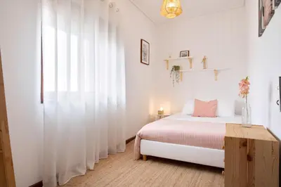 a white bedroom with a bed and a window at ! Luminous 2BR Top Floor ! Praça da República in Porto