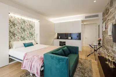 a bedroom with a bed and a living room at The Downtown Charming Apartments in Porto