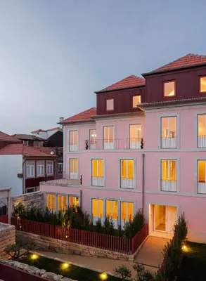 a pink building with a red fence and a door at The Downtown Charming Apartments in Porto