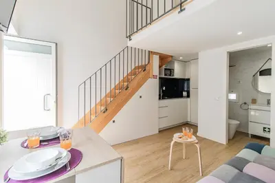 a kitchen and a living room with a staircase at Casa do Bonjardim, Lapa - Estadia no coração do Porto in Porto