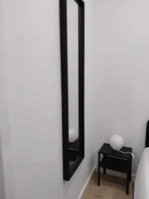 a bedroom with a mirror and a table at TMJ Apartamento in Porto