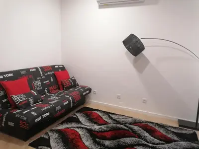 a living room with a couch and a lamp at TMJ Apartamento in Porto