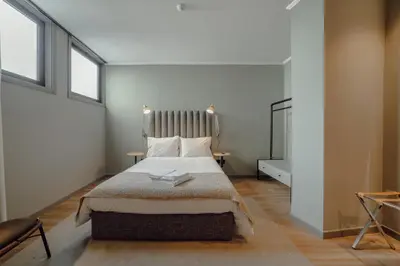 a bedroom with a large bed with two windows at River Eyes Suites in Vila Nova de Gaia