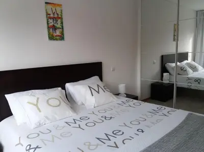 a bedroom with a bed with white sheets and a mirror at KrisApartments 2 in Porto