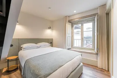 a bedroom with a large bed and a window at GuestReady - Mercadores 150 in Porto