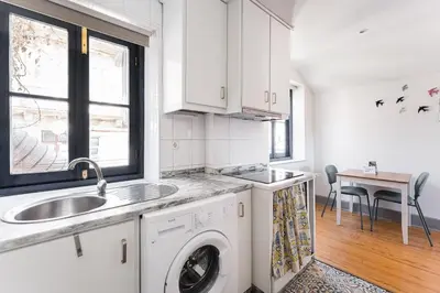 a kitchen with a sink and a washing machine at GuestReady - Modern Comfort in Downtown in Porto