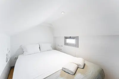 a small bedroom with a white bed and a window at GuestReady - Modern Comfort in Downtown in Porto