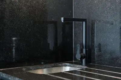 a bathroom with a sink and a faucet at GuestReady - Poet's Modern Retreat in Porto