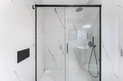 a shower with a glass door in a bathroom at GuestReady - Poet's Modern Retreat in Porto