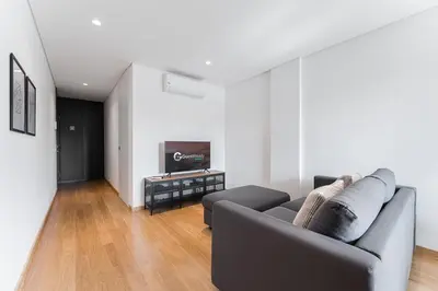 a living room with a couch and a tv at GuestReady - Poet's Modern Retreat in Porto