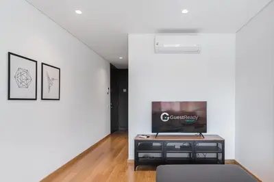 a living room with a tv on a table at GuestReady - Poet's Modern Retreat in Porto