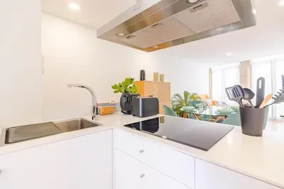 a white kitchen with a sink and a counter top at OHH- Padre António Vieira flat D - 2bedroom near the train station in Porto