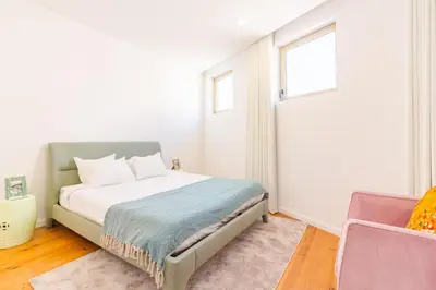 a bedroom with a bed and a window and a chair at OHH- Padre António Vieira flat D - 2bedroom near the train station in Porto