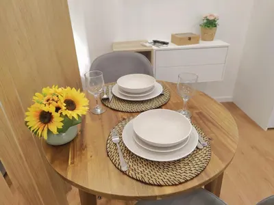 a wooden table with plates and glasses and sunflowers on it at A Window to Porto – Premium Apartment Porto Downtown in Porto