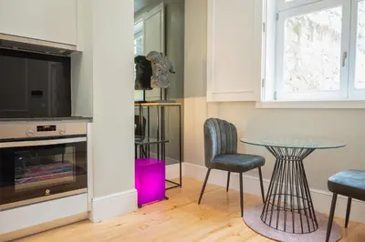 a dining room with a glass table and chairs at Cocoon Almada in Porto