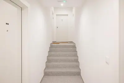 a staircase in a white room with a door at Cocoon Almada in Porto