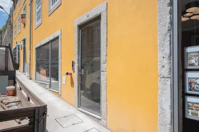 a yellow wall with glass windows on a building at Cocoon Almada in Porto