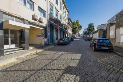 a street with cars parked on the side of the road at Travel & Live Bragas in Porto