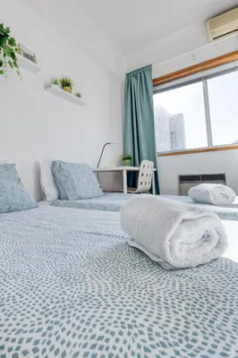 a bedroom with two beds and a window at Travel & Live Bragas in Porto