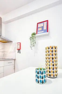 a kitchen with white walls and a white table with a vase at Travel & Live Bragas in Porto