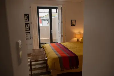 a bedroom with a bed and a table and a window at Spacious Studio w/ Balcony & AC by LovelyStay in Porto