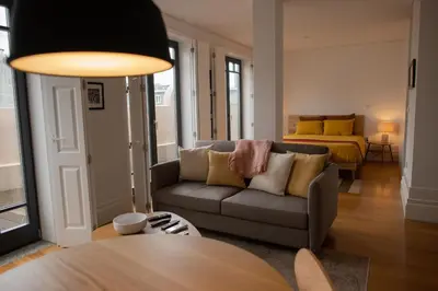a living room with a couch and a bed at Spacious Studio w/ Balcony & AC by LovelyStay in Porto