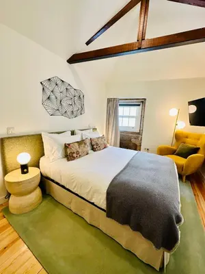 a bedroom with a large bed and a chair at CHARM APARTMENTS PORTO - Centro Batalha 1 in Porto