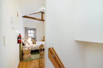 a hallway leading to a bedroom with a bed and a table at CHARM APARTMENTS PORTO - Centro Batalha 1 in Porto