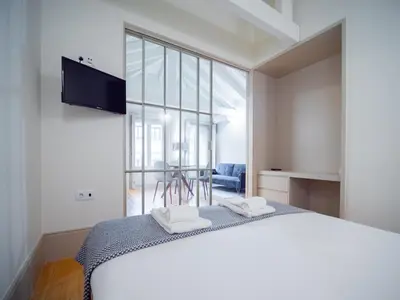 a bedroom with a bed and a large window at OportoCityView - Trindade Almada in Porto