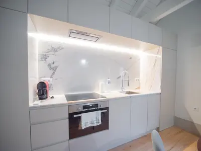 a white kitchen with a sink and a stove at OportoCityView - Trindade Almada in Porto