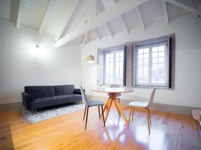 a living room with a table and chairs and a couch at OportoCityView - Trindade Almada in Porto