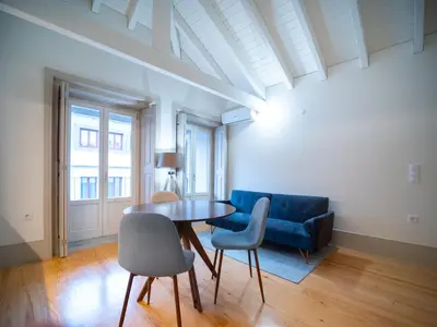a living room with a table and a blue couch at OportoCityView - Trindade Almada in Porto