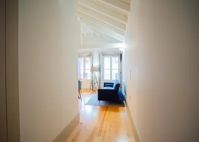 a living room with a blue chair and a couch at OportoCityView - Trindade Almada in Porto