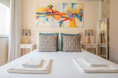 a bedroom with a white bed with two towels on it at PortoTile By RDC in Porto