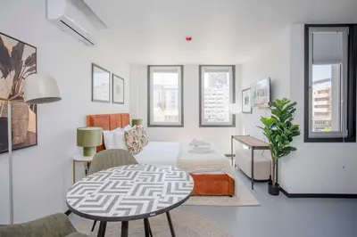 a white living room with a table and a couch at Liiiving in Porto - City Design Studios in Porto