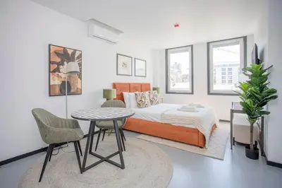 a bedroom with a bed and a table and chairs at Liiiving in Porto - City Design Studios in Porto